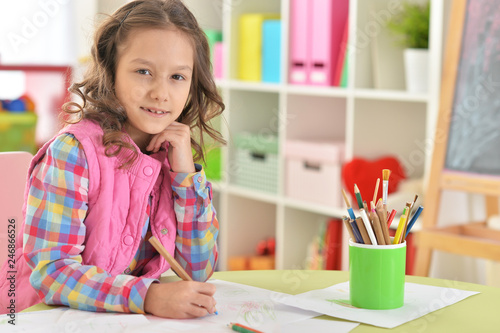 Portrait of little girl drawing at her room