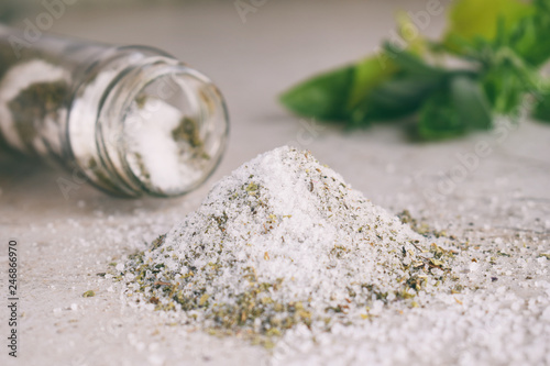 Fototapeta Naklejka Na Ścianę i Meble -  Ayurvedic herbal salt in glass jar. Sea salt with aromatic herb - rosemary, oregano, sage, marjoram, basil, thyme, mint, bay leaf. Copy space