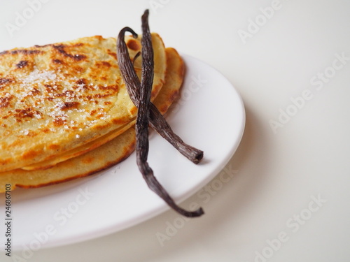 Bilde på lerret Traditional french crepe (or pancake) on a white plate, with sugar and vanilla p