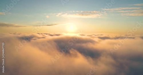 Aerial view up from the clouds to the sky in motion. Aerial view white clouds in blue sky during sunrise or sunset. Aerial top view cloudscape. Texture of clouds. Panoramic view