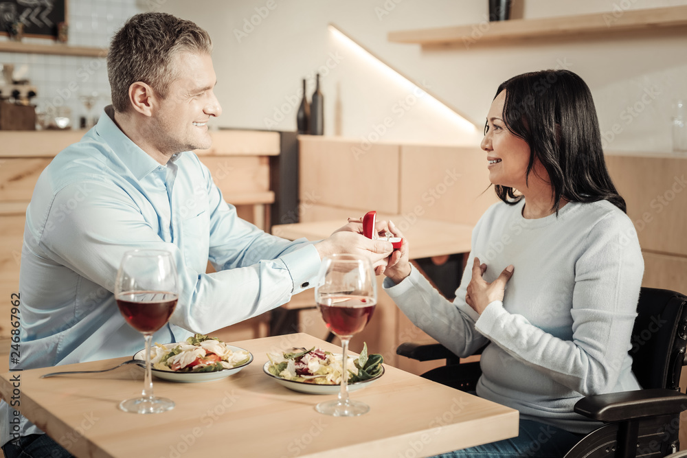 Smiling man proposing to differently abled woman Smiling man proposing to differently abled woman