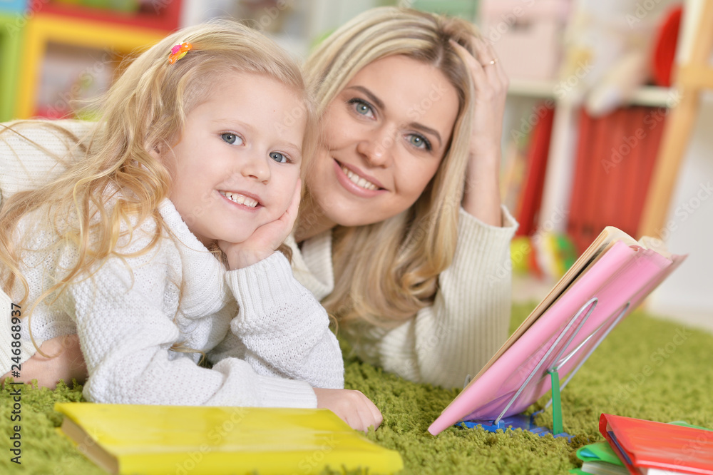 Portrait of mother with little daughter reading book Portrait of mother with little daughter reading book