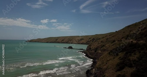 Above the waves crashing on Okains Bay Beach, New Zealand photo