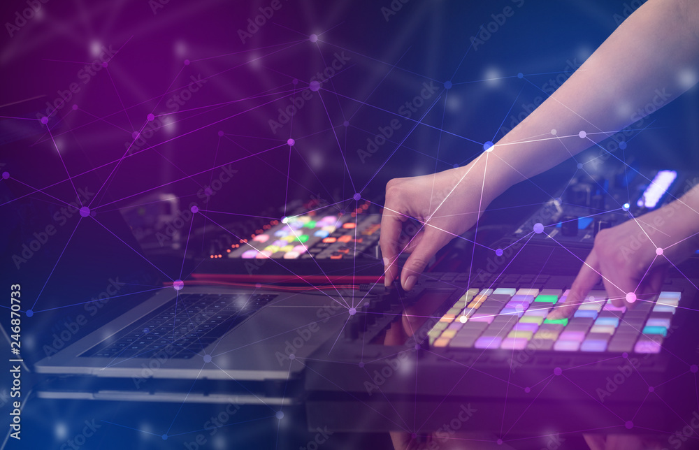 Obraz premium Hand remixing music on midi controller with colorful connectivity concept 