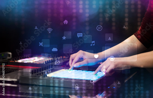 Hand mixing music on dj controller with social media concept icons
