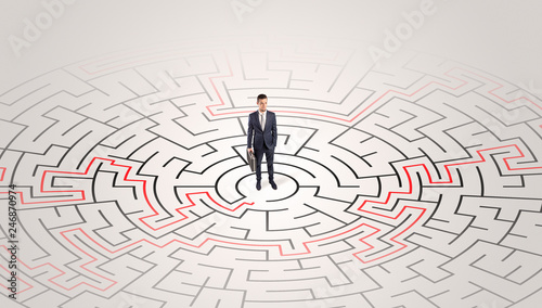 Young entrepreneur standing in a middle of a labyrinth with the solution 