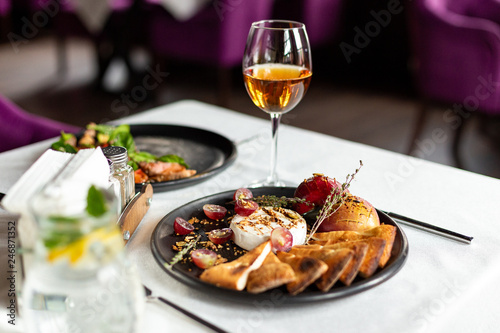 Grilled camembert with baked apple and grapes with slices of bread cakes