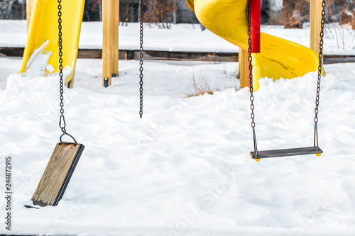 broken swing on the playground on a snowy day, the concept of old age and uselessness