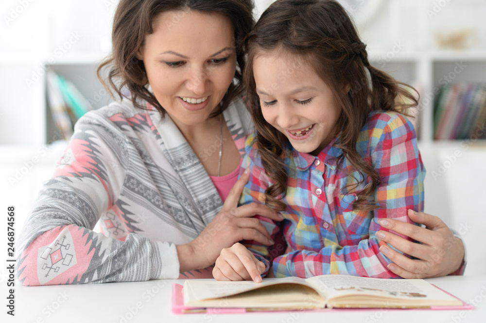 little cute girl reading book with mother little cute girl reading book with mother