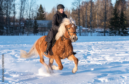 Woman horseback riding in winter