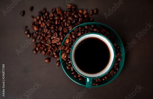 Coffee cup with roasted beans on stone background