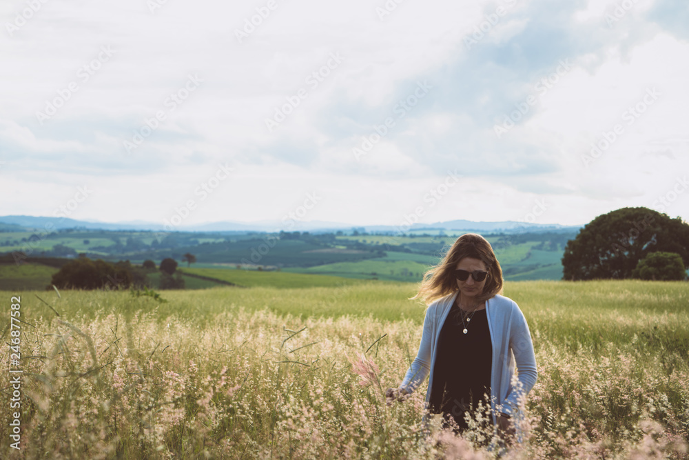 young woman having fun at sunset on a green grassy field young woman having fun at sunset on a green grassy field