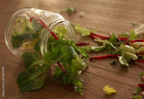 Green salat leaves and pieces of cutted beetroot in jar of glass