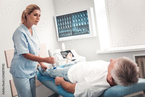 Caring young nurse asking if patient feeling okay