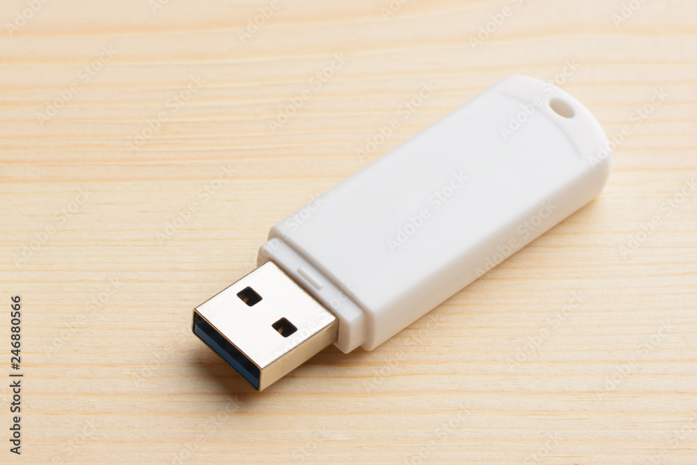 White USB stick on a light wooden table White USB stick on a light wooden table