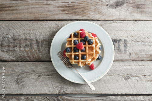 Overhead view of waffles with berries served on plate