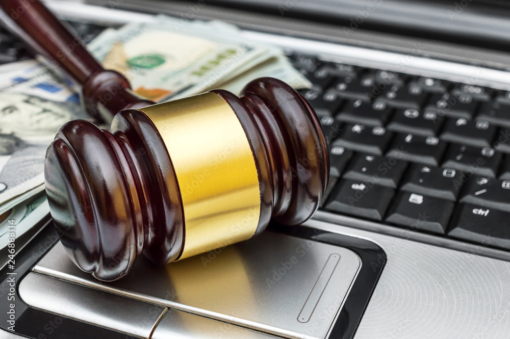 Gavel and money on laptop keyboard. Close up.