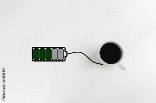 Black coffee and drawn battery charging from it. Concept of getting energy from coffee with copy space. Power charging.