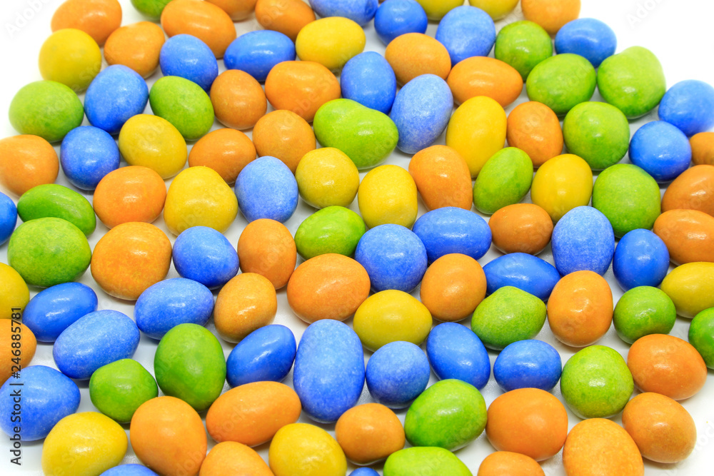 Multicolored glazed chocolate candies on a white Multicolored glazed chocolate candies on a white