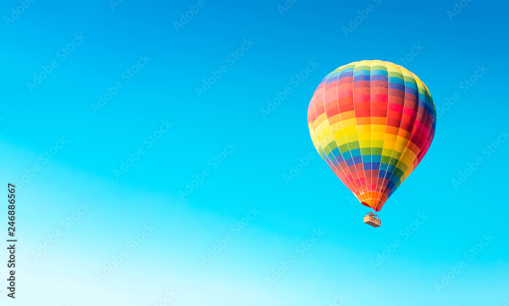 Fototapeta premium Colorful hot air balloon isolated on blue sky background. Colorful hot air balloon flying over at fairy chimneys in Nevsehir, Goreme, Cappadocia Turkey.