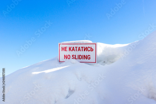Snowdrift or skid. Avalanche site. Warning sign for skiers and snowboarders. Rules skiing at a ski resort. Warning of danger. A sign with a prohibitory inscription. Winter background.