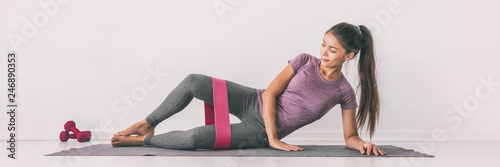 Obraz na płótnie Resistance band clamshell exercise fit girl training legs on floor mat demonstration