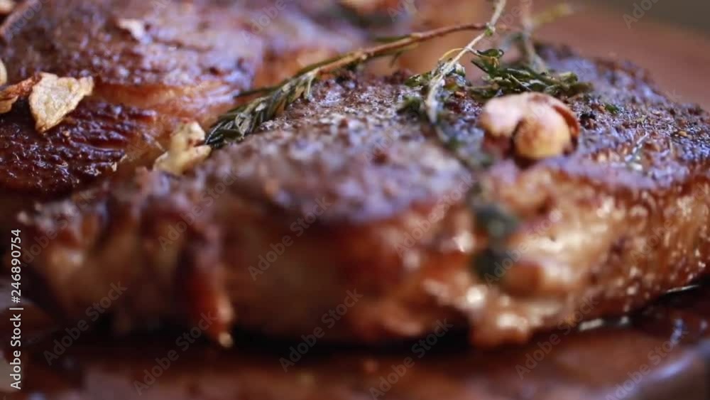 fresh cooked steaks on a wooden board with thyme and garlic fresh cooked steaks on a wooden board with thyme and garlic