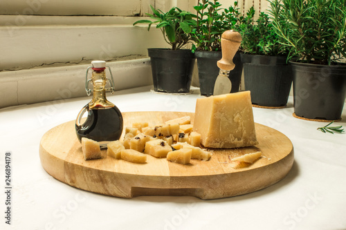 Cut into cubes Parmesan cheese and balsamic vinegar on wooden surface
