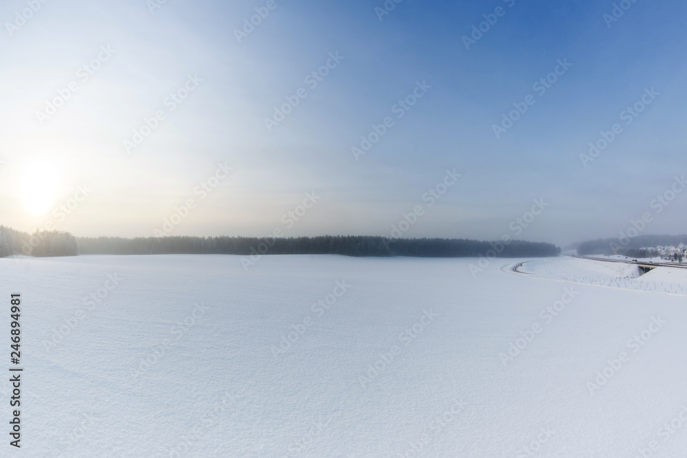 Winter landscape with snow field and road