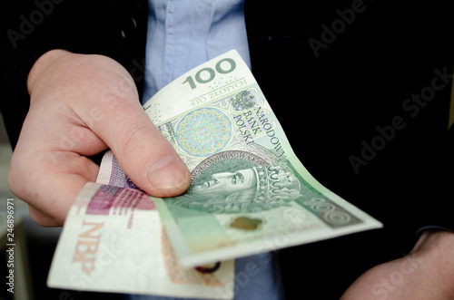 Businessman in suit giving money. One hundred and twenty Polish zloty, close up