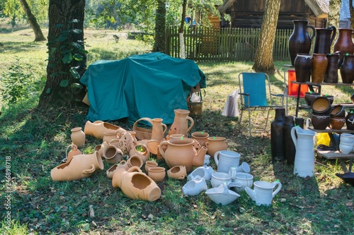 folk festival in the park combined with trade, makeshift stall on the grass, sale of hand-made pots and craft products