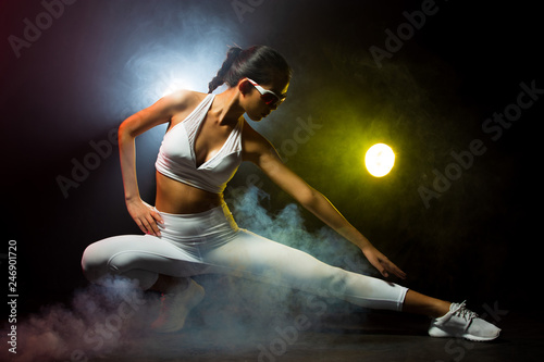 Asian Tan Skin Fitness women exercise wear white gear suit in Fog Smoke Dark background environment, studio lighting yellow back light copy space, concept ready start to run sunglasses