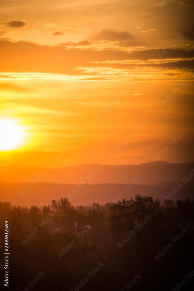 Hazy colorful mountain sunrise in Redding California, with orange, red and yellow colors