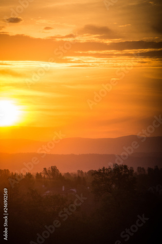 Hazy colorful mountain sunrise in Redding California, with orange, red and yellow colors
