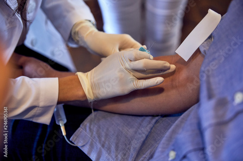 female phlebotomist drawing blood from a caucasian man