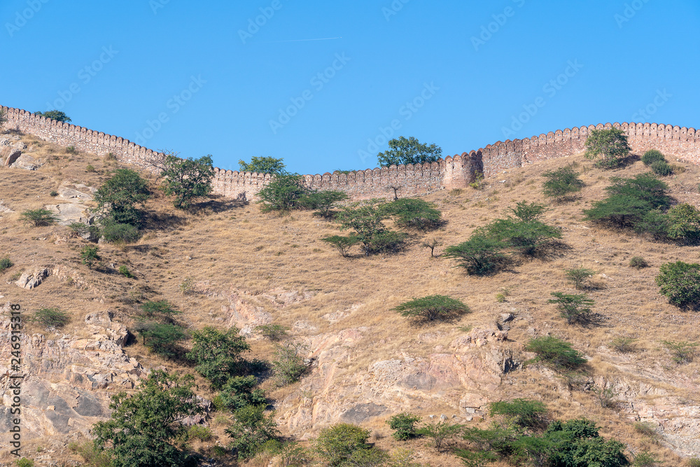 The long wall on the mountain of Amber fort in historical city of Amer, Jaipur, Rajasthan, India The long wall on the mountain of Amber fort in historical city of Amer, Jaipur, Rajasthan, India