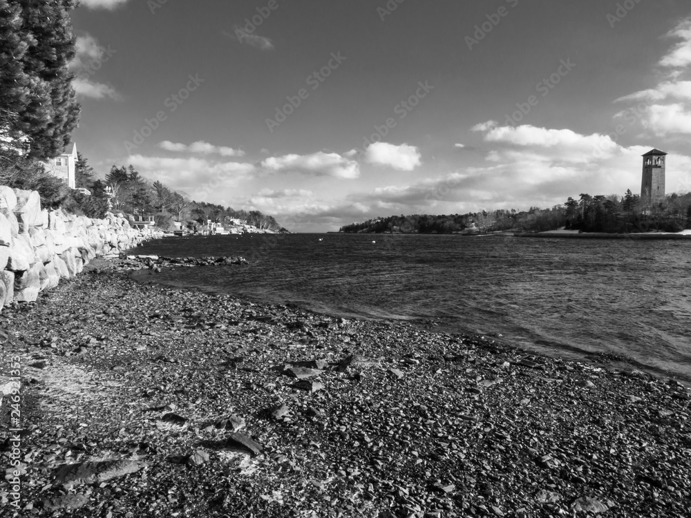 winter landscape with ice on rock shore and clouds