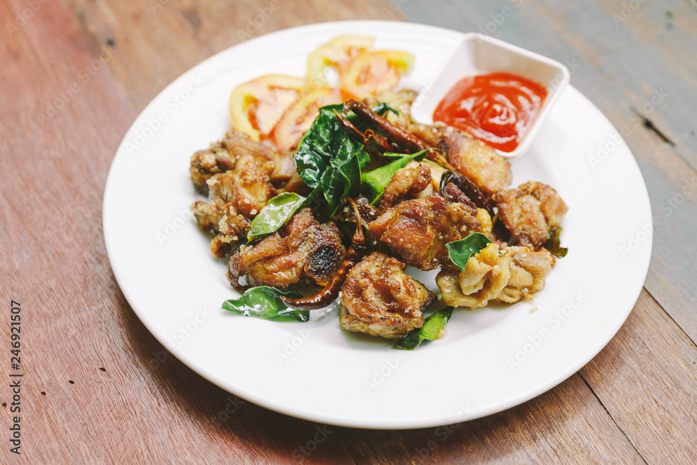 Thai style stir fried thighs chicken with salt and chili. Served with chili sauce.