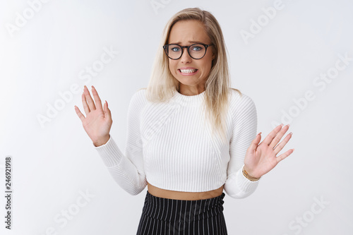 Gross it so disgusting. Displeased and bothered silly glamour woman in glasses with blond hair move away from nasty and unpleasant thing raising palms clenching teeth from dislike and reluctance