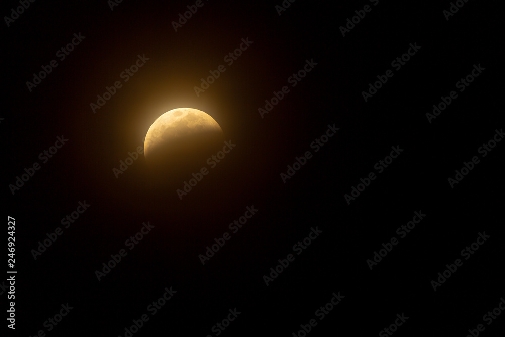 Full Lunar Eclipse in January 2019 is pictured in various stages of the eclipse. The bright white moon turns dark and black and eventually a yellowish orange that glows in the dark night sky Full Lunar Eclipse in January 2019 is pictured in various stages of the eclipse. The bright white moon turns dark and black and eventually a yellowish orange that glows in the dark night sky