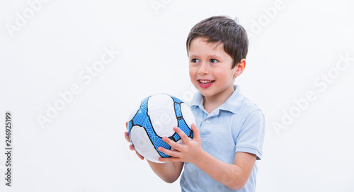 Boy playing with soccer ball, isolated on white studio background. Portrait of kid football player with ball in hand. Young cute male holding sport equipment. Education conceptual picture.