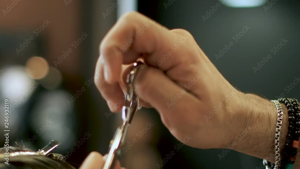 Hands of barber cut hair. Comb and scissors. Basic barbering techniques. Barber trimming hair