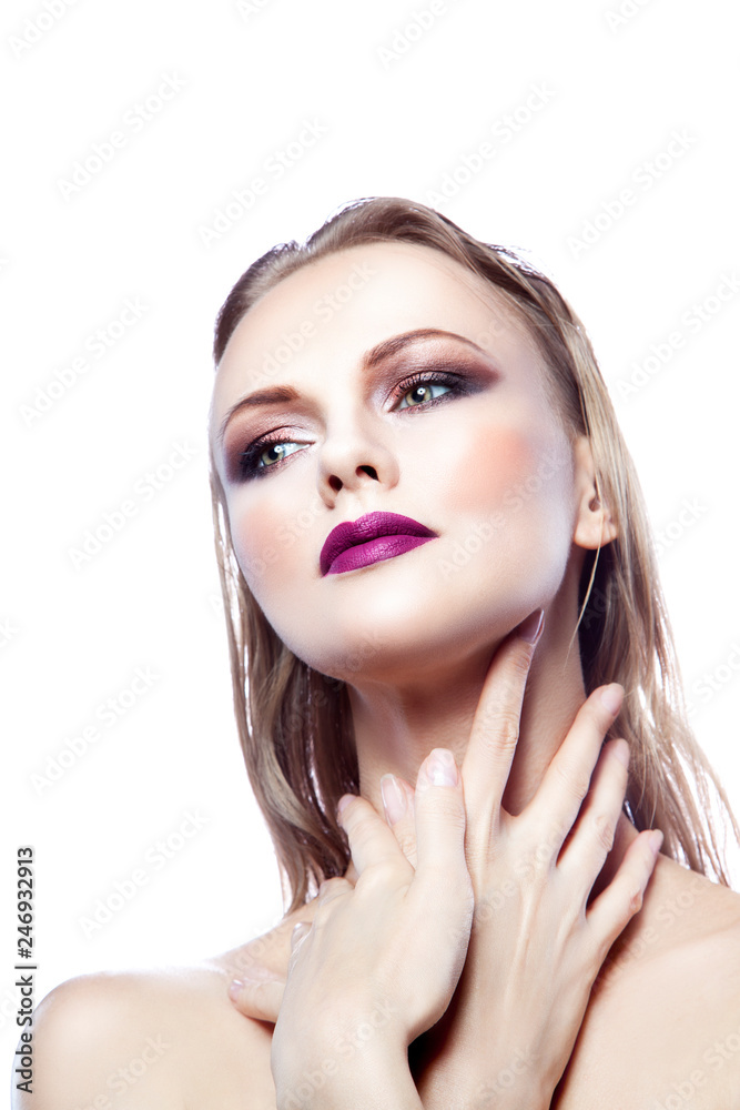 Fototapeta premium Close-up beauty model woman face looking at side. Purple lips, smokey eye shadow make-up, healthy clean skin. White background