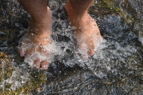 Feet Man in waterfall ,Lifestyle Travel concept waterfall in the forest