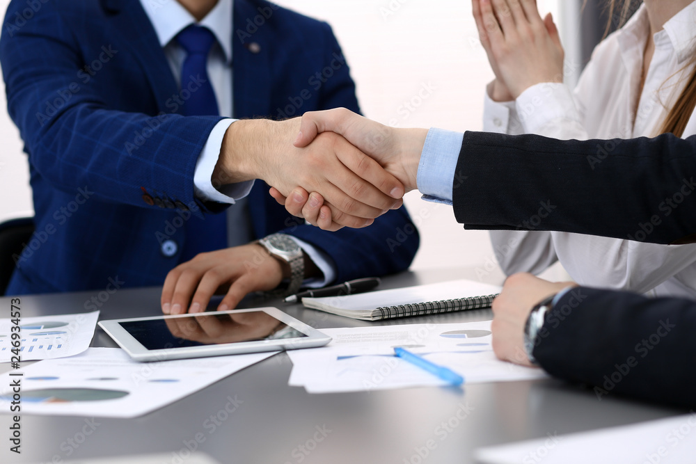 Business people shaking hands, finishing up a papers signing. Meeting, agreement and lawyer consulting concept Business people shaking hands, finishing up a papers signing. Meeting, agreement and lawyer consulting concept