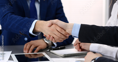 Business people shaking hands, finishing up a papers signing. Meeting, agreement and lawyer consulting concept