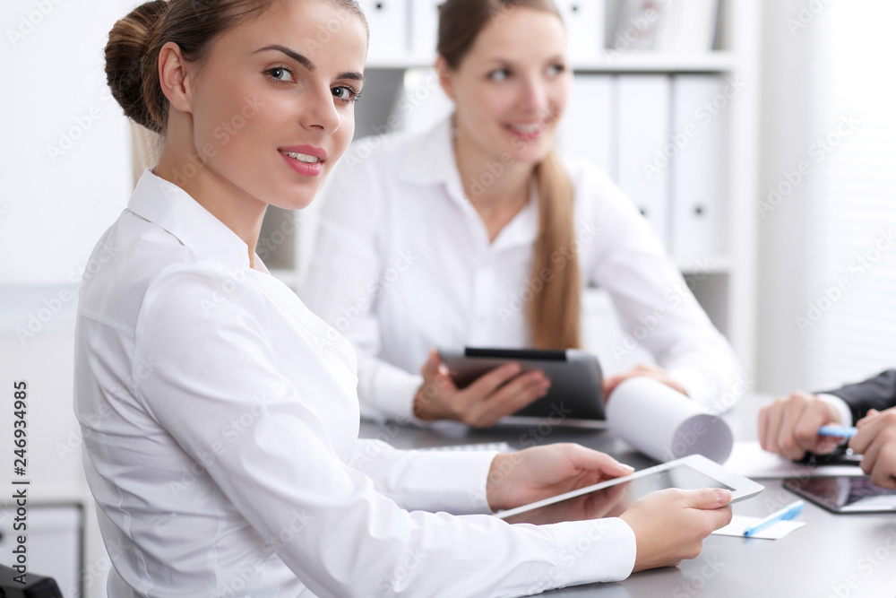 Group of business people at meeting on the background of office. Focus at a beautiful brunette woman Group of business people at meeting on the background of office. Focus at a beautiful brunette woman