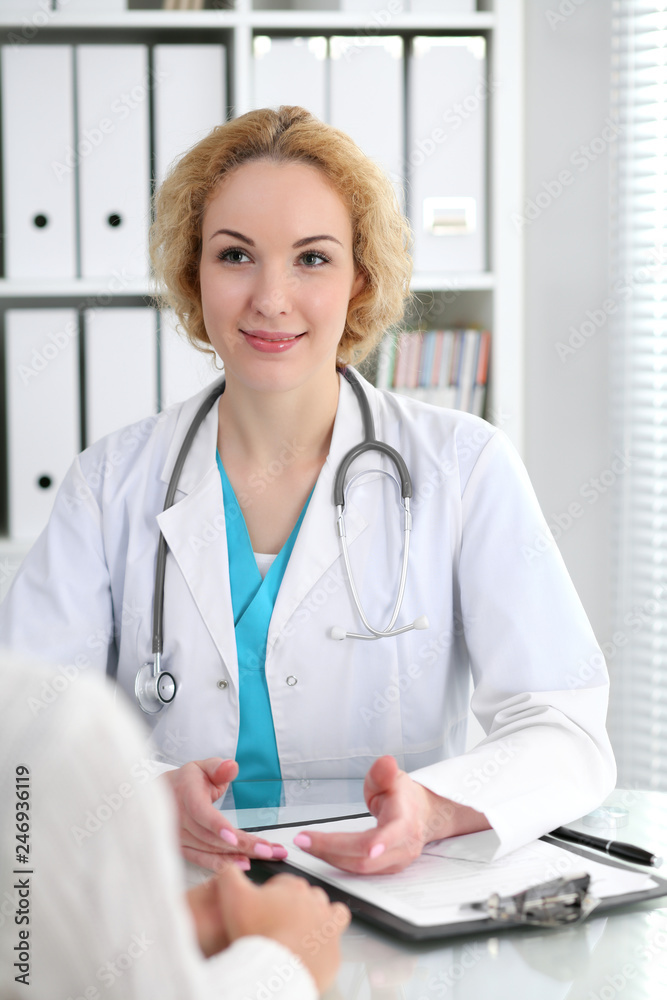 Happy blonde female doctor and patient discussing medical examination results. Medicine, healthcare and help concept Happy blonde female doctor and patient discussing medical examination results. Medicine, healthcare and help concept