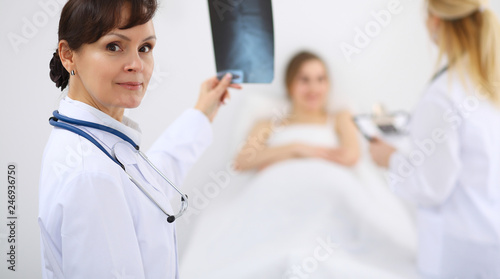 Female doctor at the background with patient. Physician at work