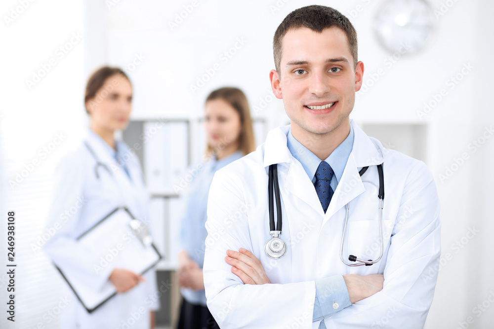 Friendly male doctor on the background of a female physician in hospital office Friendly male doctor on the background of a female physician in hospital office